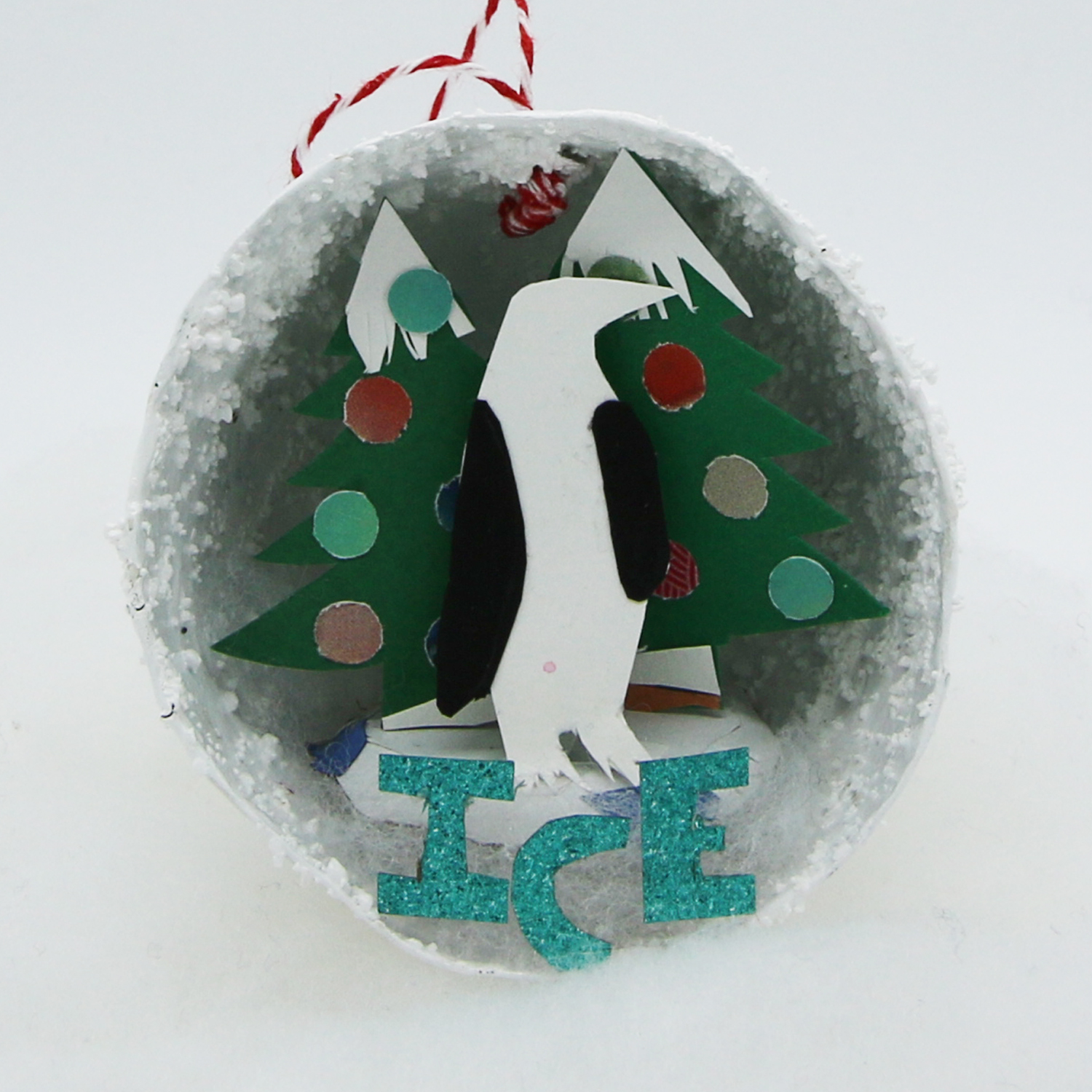 Boule de Noël avec pingouin en papier découpé